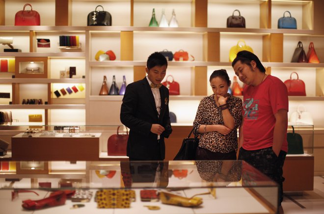 A couple shop at a Louis Vuitton store during Vogue's 4th Fashion's Night Out: Shopping Night with Celebrities in downtown Shanghai September 7, 2012. Louis Vuitton is courting China's wealthy with one-of-a-kind shoes and bags it is branding as unique works of art to reclaim its exclusive cachet in the luxury market. REUTERS/ Carlos Barria  (CHINA - Tags: FASHION BUSINESS SOCIETY WEALTH) - RTR37MSO