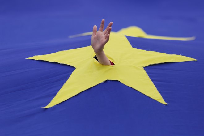 A child waves his hand through a cut made in one of the stars that make up the European Union flag, during a support rally organised to mark the EU&#39;s 60th anniversary of the Treaty of Rome in downtown Bucharest, Romania, March 25, 2017. Inquam Photos/Octav Ganea/via REUTERS ATTENTION EDITORS - THIS IMAGE WAS PROVIDED BY A THIRD PARTY. EDITORIAL USE ONLY. ROMANIA OUT. NO COMMERCIAL OR EDITORIAL SALES IN ROMANIA. - RTX32OBG Foto Inquam Photos Reuters