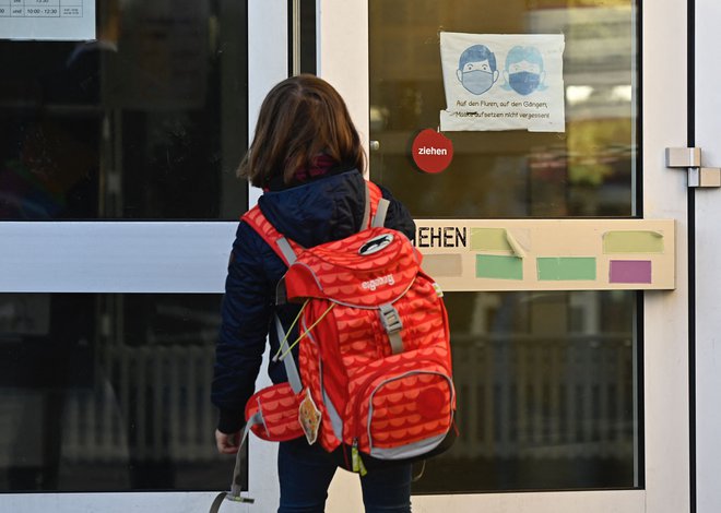 Vračanje učencev nižjih razredov osnovne šole spet v šole. FOTO: Tobias Schwarz/Afp