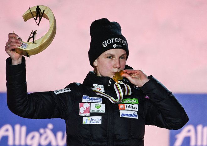Ema Klinec je takole poljubila zlato kolajno za naslov svetovne prvakinje na srednji skakalnici v Oberstdorfu. FOTO: Christof Stache/AFP