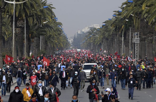 Podporniki zmerno islamistične stranke Ennahda mahajo z državnimi in strankinimi zastavicami med demonstracijami proti predsedniku Kaisu Saiedu in v podporo tunizijski vladi v prestolnici Tunis. FOTO: Fethi Belaid/Afp