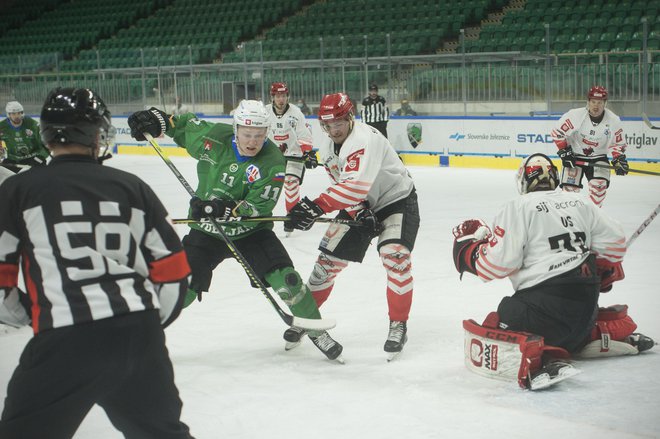 Olimpijini hokejisti (na fotografiji v zelenem dresu ljubljanski Finec Juuso Pulli) so se v derbiju izkazali z bolj všečno igro in zasluženo zmago. FOTO: Jure Eržen/Delo