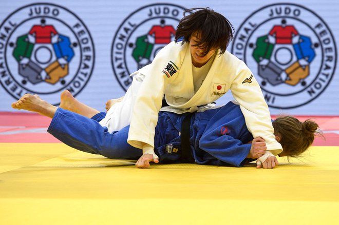 Taširo Miku (zgoraj) je v finalu kategorije do 63 kg velikega slama v Taškentu ugnala Andrejo Leški (modri kimono). FOTO: Aleksander Nemenov/AFP