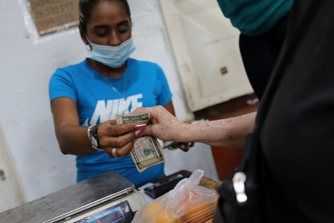 Dolar v vsakdanjem življenju vse bolj izpodriva bolivar.&nbsp;FOTO: Manaure Quintero/Reuters