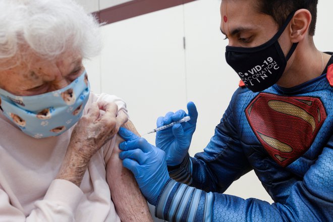 Doktor Mayank Amin daje cepivo Pfizer 94-letni Helen Pepe v kliniki v Collegevilleu v Pensilvaniji. FOTO: Hannah Beier/Reuters