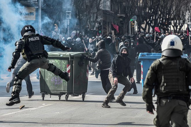 Protestniki med spopadi v Solunu mečejo kamenje na policijo. Po celotn i Grčiji na tisoče študentov sodeluje na demonstracijah proti operaciji evakuacije univerze Aristotel s strani policije. FOTO: Sakis Mitrolidis/Afp