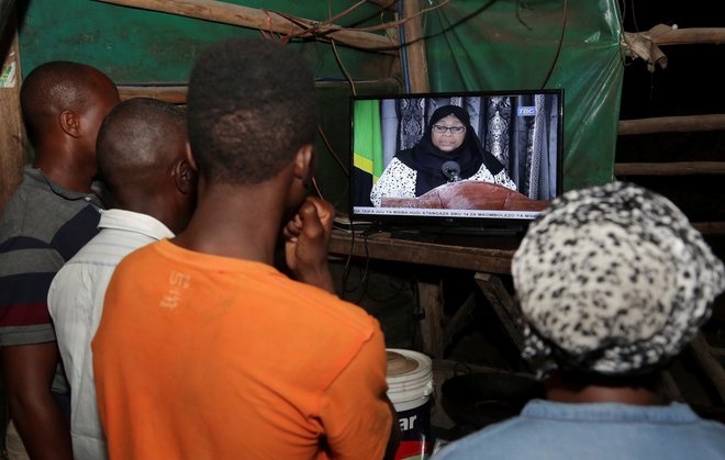 Prebivalci Tanzanije med televizijskim prenosom slovesnosti, na kateri je zaprisegla prva tanzanijska predsednica. FOTO: Stringer/Reuters