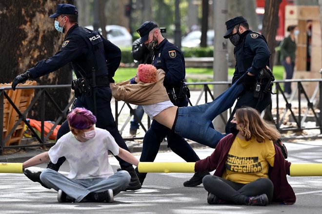 V Madridu je policija z uporabo sile odstranila aktiviste, ki so z blokado glavne ulice pred ministrstvom za zdravje zahtevali ukrepe proti podnebnim spremembam. FOTO: Gabriel Bouys/Afp