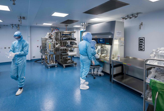 Na fotografiji so uslužbenci nemškega podjetja Biontech v čisti sobi, kjer izdelujejo cepivo mRNK. FOTO:&nbsp;Thomas Lohnes/AFP