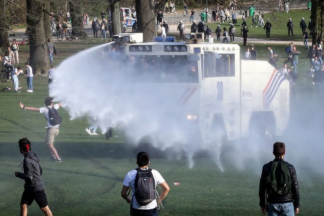 Mladi v Bruslju so se, siti omejevalnih ukrepov, množično zbrali v parku, posredovala je tudi policija z vodnim topom. Foto Francois Walschaerts/AFP