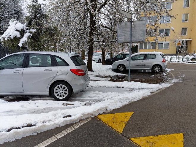 Pod aprilskim snegom na zelenem pasu pred bloki v Šiški ni več trave, so samo še luže in blato. FOTO: Aleš Stergar/Delo