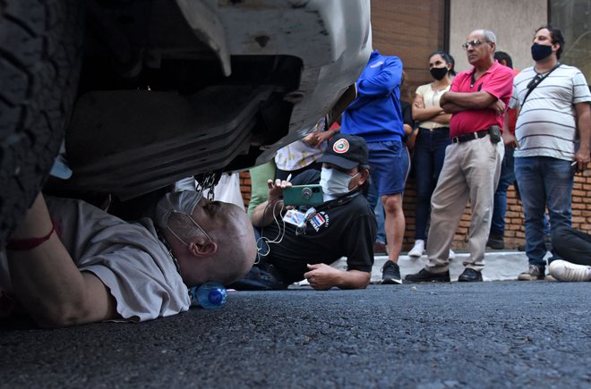 Nekdanji paragvajski opozicijski senator Paraguay Cubas se je priklenil na policijski avto med protestom v Asuncionu. Cubas je obsodil uporabo policijskega avtomobila za domnevne osebne namene. FOTO: Daniel Duarte/Afp