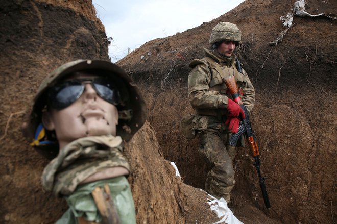 Na obrobju ukrajinskega mesta Zolote v Luganski regiji se vojak sprehaja v rovu na frontni črti, kjer potekajo vse pogostejši spopadi s strani Rusije podprtimi separatisti. FOTO: Stringer/Afp