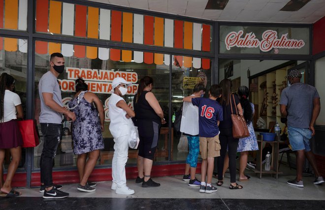 &raquo;Stojim v vrsti in čakam, ne vem, kaj imajo, to vidiš šele, ko trgovino odprejo. V vrsti sem od petih zjutraj, odprli bodo ob devetih.&laquo; FOTO: Alexandre Meneghini/Reuters