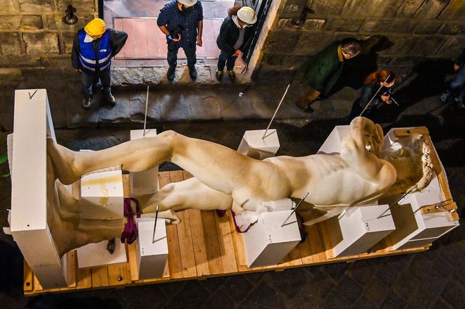 Pogled na 3D natisnjeno digitalno natančno kopijo Michelangelovega kipa mladega bojevnika Davida, narejenega iz akrilne smole, prekrite z marmornatim prahom v delavnici v Firencah. Kip bo predstavljal Italijo na prihajajočem sejmu Expo 2021 v Dubaju. Za duplikat 17-metrskega šesttonskega marmornatega kipa, ki stoji v Galleria dell &rsquo;Accademia v Firencah, je bila potrebna ekipa umetnostnih zgodovinarjev, tehnikov in inženirjev, pa tudi najsodobnejša tehnologija, kot so digitalno skeniranje, laserji in eden največjih svetovnih 3D tiskalnikov. Cilj tega projekta, ki ga podpira Galleria dell&rsquo;Accademia, je predstaviti prednosti uporabe 3D tiskanja v umetnosti. FOTO: Carlo Bressan/Afp