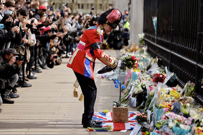 Oboževalec kraljeve družine je bil eden od mnogo Londončanov, ki so k ograji Buckinghamske palače prejšnji teden položili cvetje v spomin na pokojnega princa Filipa. Foto: Tolga Akmen/AFP