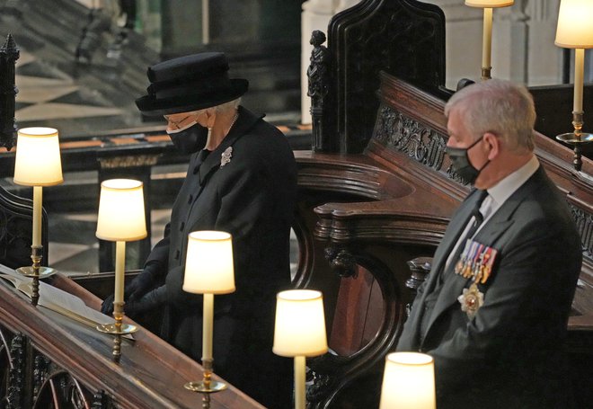 Kraljica je prvič sedela sama. Zaradi pandemije novega koronavirusa pa so tudi drugi sedeli ločeno. FOTO: Reuters