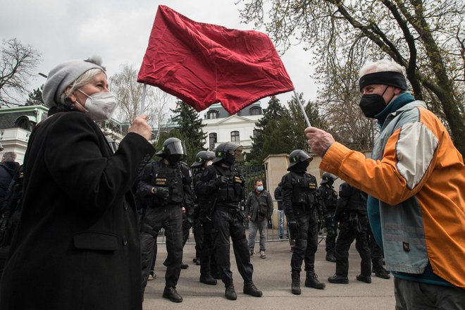 Demonstranti z dvignenjo rdečo &#39;zastavo&#39; &#39; med shodom pred ruskim veleposlaništvom v Pragi. FOTO:&nbsp;FOTO: Michal Cizek/AFP