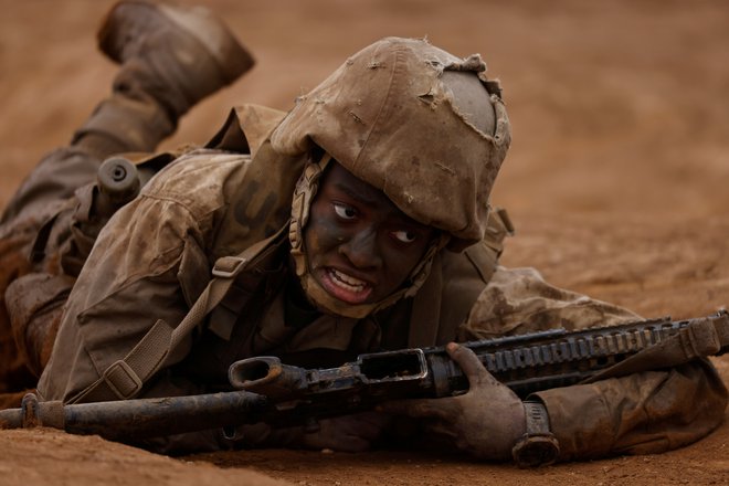 Rekrutka ameriškega mornariškega korpusa v San Diegu sodeluje na napornem treningu, ko njen vod premaguje ovire. Dotična mladenka je postala prva marinka v vojaškem kampu Pendleton v Kaliforniji. FOTO: Mike Blake/Reuters