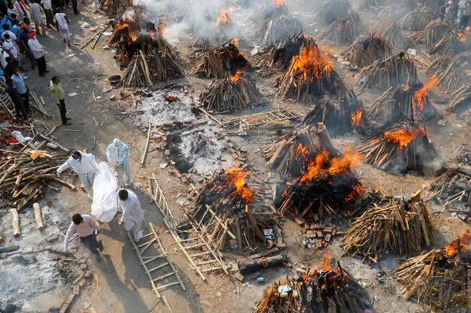 Množična kremacija umrlih s covidom v New Delhiju. FOTO: Adnan Abidi/Reuters