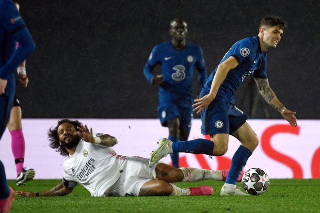 Christian Pulišić (desno) je spravil v težave Realovo obrambo in nezanesljivega Marcela (na tleh). FOTO: Pierre-Philippe Marcou/AFP