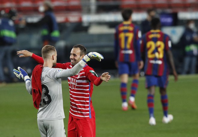 Nogometaši Granade se veselijo uspeha, gostitelji razočarano zapuščajo igrišče na štadionu Camp Nou. FOTO: Albert Gea/Reuters