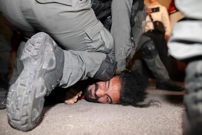 V jeruzalemski soseski Sheikh Jarrah izraelske varnostne sile aretirajo Palestinca, ko se palestinske družine soočajo z deložacijo. FOTO: Ahmad Gharabli/Afp