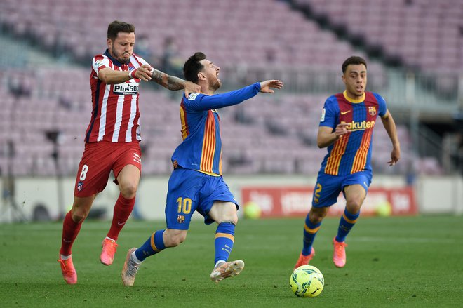 Takole je Oblakov soigralec Saul Niguez poskusil ustaviti Barceloninega zvezdnika Lionela Messija. FOTO: Josep Lago/AFP