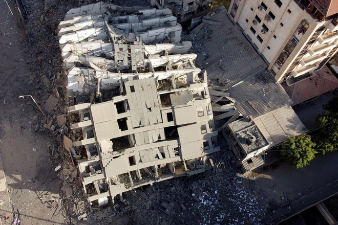 Slika, posneta z brezpilotnim letalom, prikazuje ostanke zgradbe, ki je bila uničena med napadi. FOTO: Mohammed Salem/Reuters