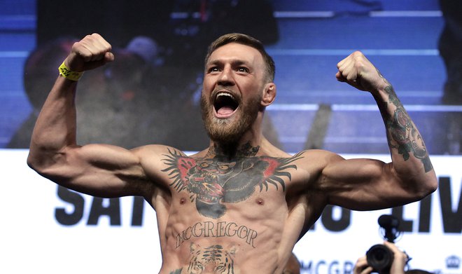 Borec v mešanih borilnih veščinah Conor McGregor v oktagonu izgublja, a zmaguje v poslu. FOTO: John Gurzinski/AFP