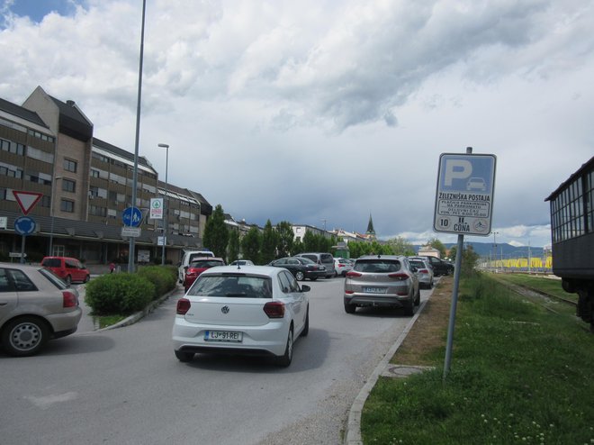 Prvi del parkirišča pri železniški postaji je nabito poln, odkar je 40 parkirnih mest na tem parkirišču ločenih z zapornico. FOTO: Špela Kuralt/Delo