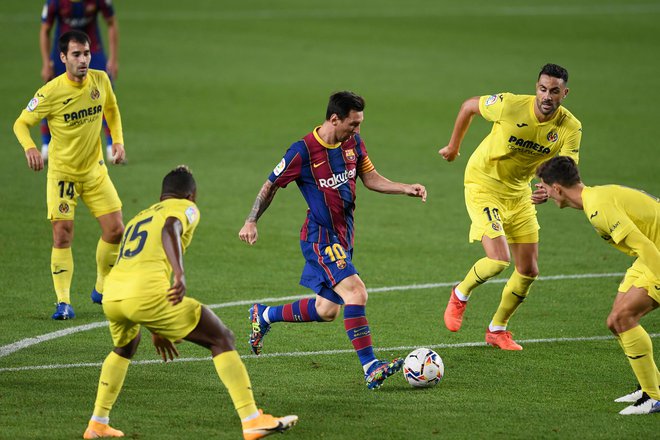 Lionel Messi obkrožen z igralci Villarreala, imenovanega tudi rumena podmornica, saj igralci nosijo rumene drese. FOTO:Josep Lago/AFP