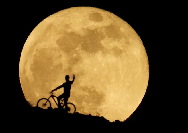 Na nebu smo lahko opazovali neverjeten pojav super lune. Luna je bila videti večja, svetlejša in bolj rdeča kot običajno, saj je v nekaterih delih sveta prišlo do sočasnega pojava super lune in luninega mrka. Ko pride najbližje Zemlji luna izgleda približno 17 odstotkov večja in 30 odstotkov svetlejša od najslabše Lune v letu, ko je v svoji orbiti najbolj oddaljena od Zemlje. FOTO: Borja Suarez/Reuters