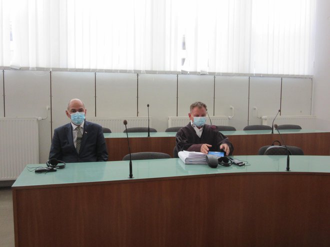 Premier Janez Janša se je začetka obravnave udeležil, potem pa se zaradi obveznosti opravičil in se strinjal s sojenjem v nenavzočnosti. Zastopal ga je odvetnik Franci Matoz (desno). FOTO: Špela Kuralt/Delo