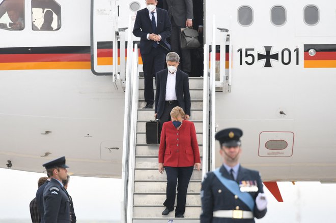 Nemška kanclerka Angela Merkel in njen mož Joachim Sauer ob prihodu na letališče v britanskem Cornwallu, kjer poteka zasedanje skupine G7. FOTO: Stefan Rousseau/AFP