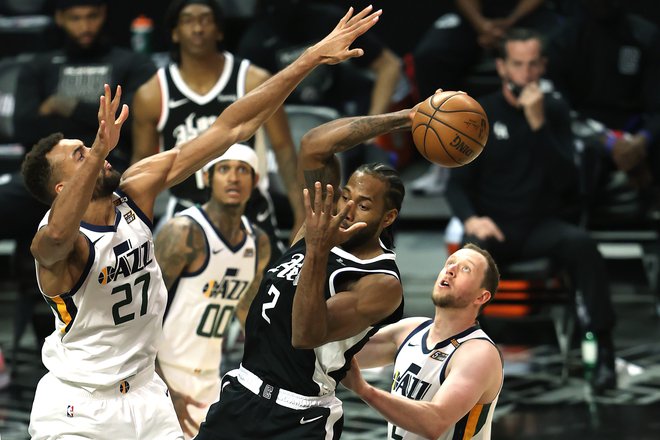 Ko je Kawhi Leonard (v sredini) razigran, mu niti najboljši obrambni košarkar v NBA Rudy Gobert (levo) ni kos. FOTO: Sean M. Haffey/AFP