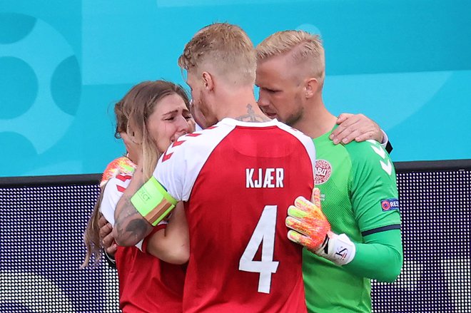 Kasper Schmeichel in Simon Kjaer sta ob robu igrišča tolažila Eriksenovo ženo Sabrino, medtem ko so vsi skupaj nemočno spremljali njegovo oživljanje na zelenici. FOTO: Wolfgang Rattay/AFP