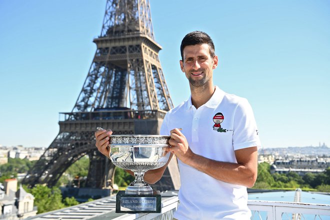 Novak Đoković je ponosno pred znamenitim pariškim stolpom pokazal svojo 19. lovoriko s turnirjev za grand slam.<br />
FOTO: Christophe Archambault/AFP