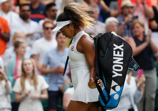 Naomi Osaka zapušča turnir v Wimbledonu leta 2019, ko je bila od nje že v prvem krogu boljša Kazahstanka Julija Putinceva. FOTO: Adrian Dennis/AFP