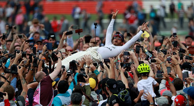 Domači favorit Lewis Hamilton proslavlja na rokah navijačev v Silverstonu leta 2017. FOTO: Jason Cairnduff/Reuters