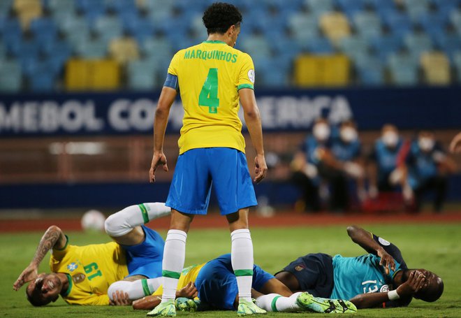 V bolečinah sta v Goianii obležala Brazilec Everton in Ekvadorec Enner Valencia, vse skupaj je nadziral Marquinhos. FOTO: Diego Vara/Reuters