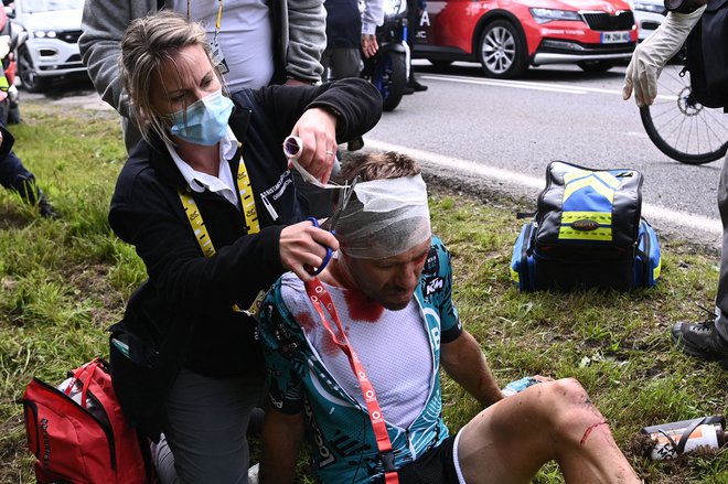 Francozu Cyrilu Lemoinu&nbsp;pomagajo po nesreči, ki je že v prvi etapi pretresla karavano na dirki po Franciji. FOTO: Anne-christine Poujoulat/AFP