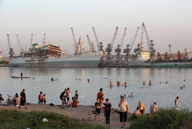 Iračani se hladijo ob reki Šat al Arab Shatt, v bližini pristanišča pri mestu Basra. FOTO: Hussein Faleh/Afp