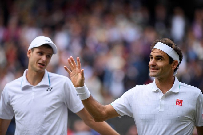 Roger Federer je v hipu športno čestital zmagovalcu Hubertu Hurkaczu. FOTO: Edward Whitaker/AFP