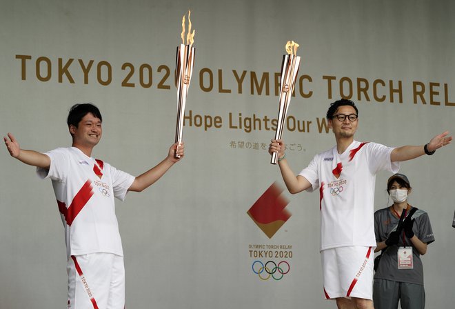 V nič kaj veselem vzdušju je olimpijska bakla prispela v Tokio. FOTO: Naoki Ogura/Reuters
