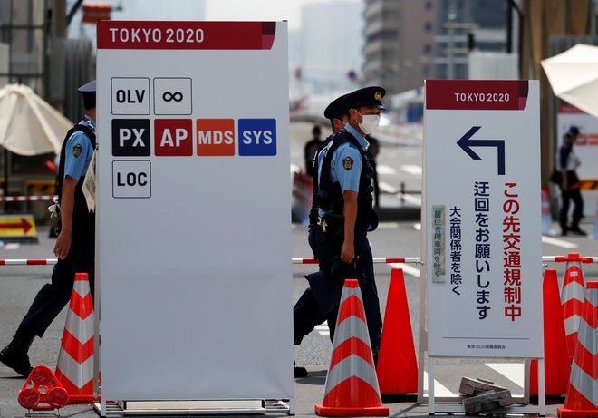 Deset dni pred začetkom iger policisti nadzirajo vhod v olimpijsko vas. FOTO: Issei Kato/Reuters