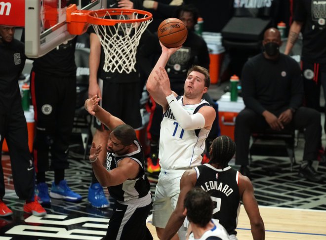 Luka Dončić (z žogo) med sedmo tekmo letošnjega prvega kroga končnice lige NBA, v katerem je Dallas spet ustavila ekipa Los Angeles Clippers. FOTO: Kirby Lee/USA Today Sports