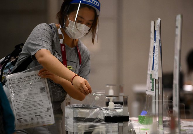 Japonski prireditelji OI so v dnevnem poročilu navedli, da so pred petkovim slovesnim odprtjem iger v Tokiu odkrili osem&nbsp;novih pozitivnih primerov na covid-19. FOTO: Franck Fife/AFP