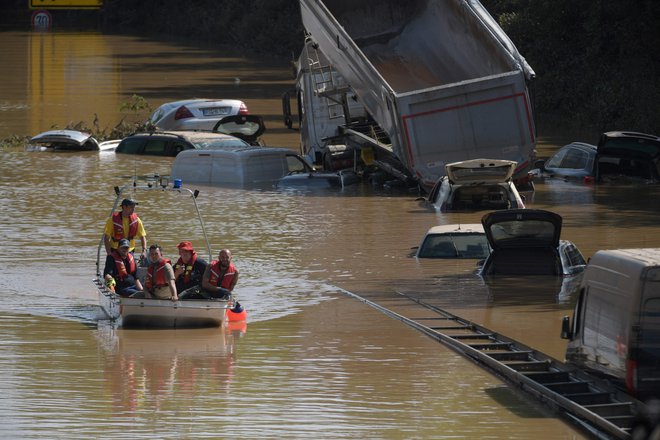 Reševalni čoln patruljira ob potopljenih avtomobilih in drugih vozilih na poplavljenem odseku zvezne avtoceste v Erftstadtu v zahodni Nemčiji. FOTO: Sebastien Bozon/AFP