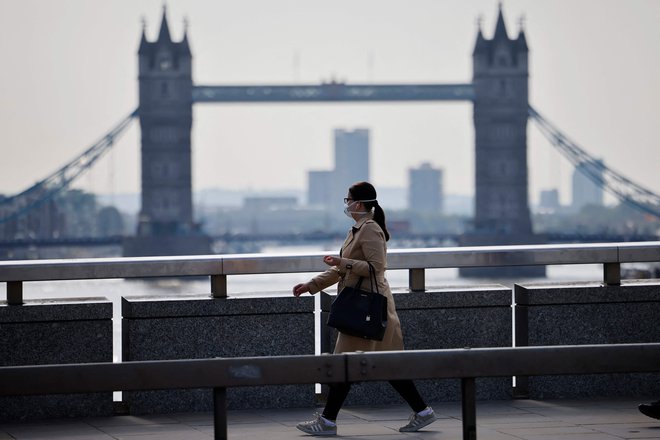 Kljub temu da je Anglija zaradi visoke precepljenosti ukinila skoraj vse omejitve, v Londonu še vedno srečamo ljudi z zaščitno masko. Foto Tolga Akmen/AFP